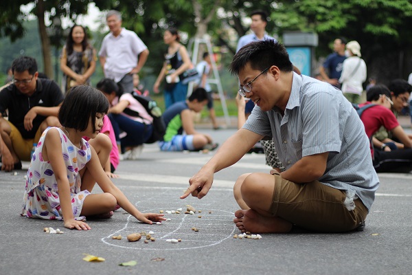 Playing Mandarin Square capturing - O an quan in Hoan Kiem lake on weekend 