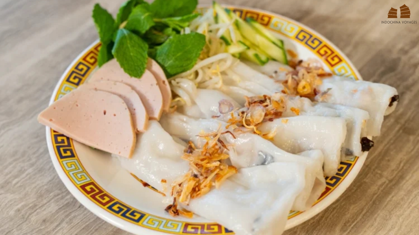 Plate of banh cuon rice rolls with fried shallots, cha slices, herbs and bean sprouts in Hanoi
