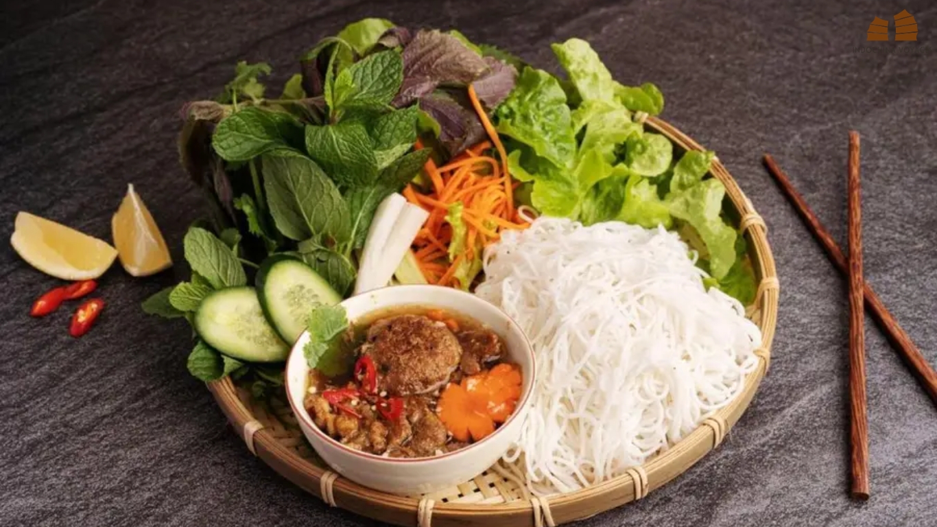 Bun cha served with grilled pork in dipping broth, rice noodles and fresh herbs on a bamboo tray in Hanoi