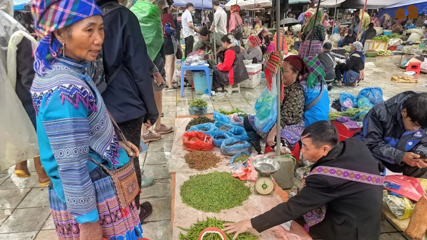 Vendors selling fresh chilies and greens at a rainy Ha Giang local market