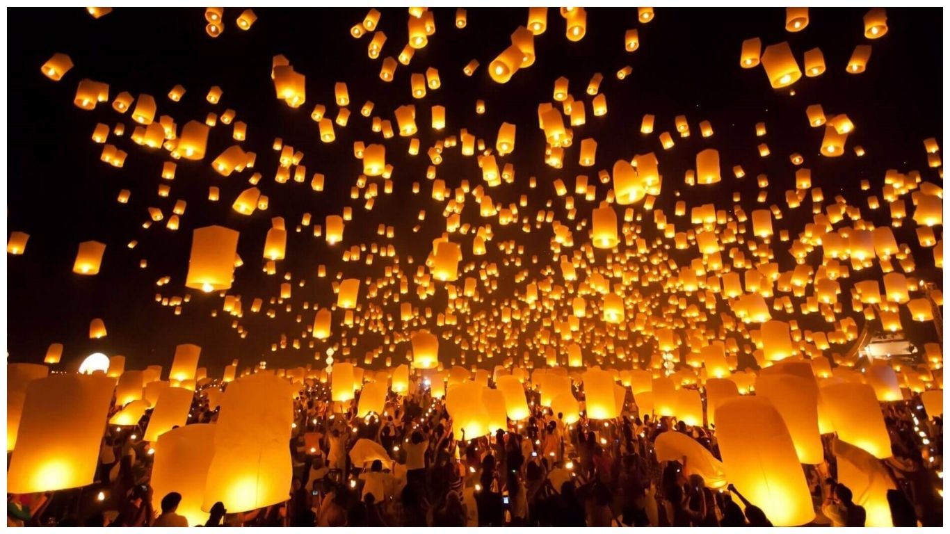 Thousands of glowing paper lanterns filling the night sky during the Yi Peng Festival in Chiang Mai, showcasing the vibrant culture and Thailand in December weather.