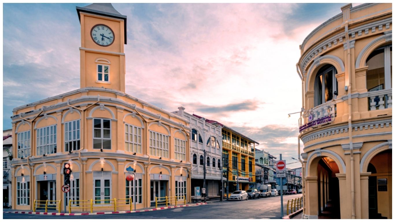 The iconic yellow Sino-Portuguese clock tower building in Phuket Old Town at sunset, showcasing historic architecture under a soft pink and blue sky