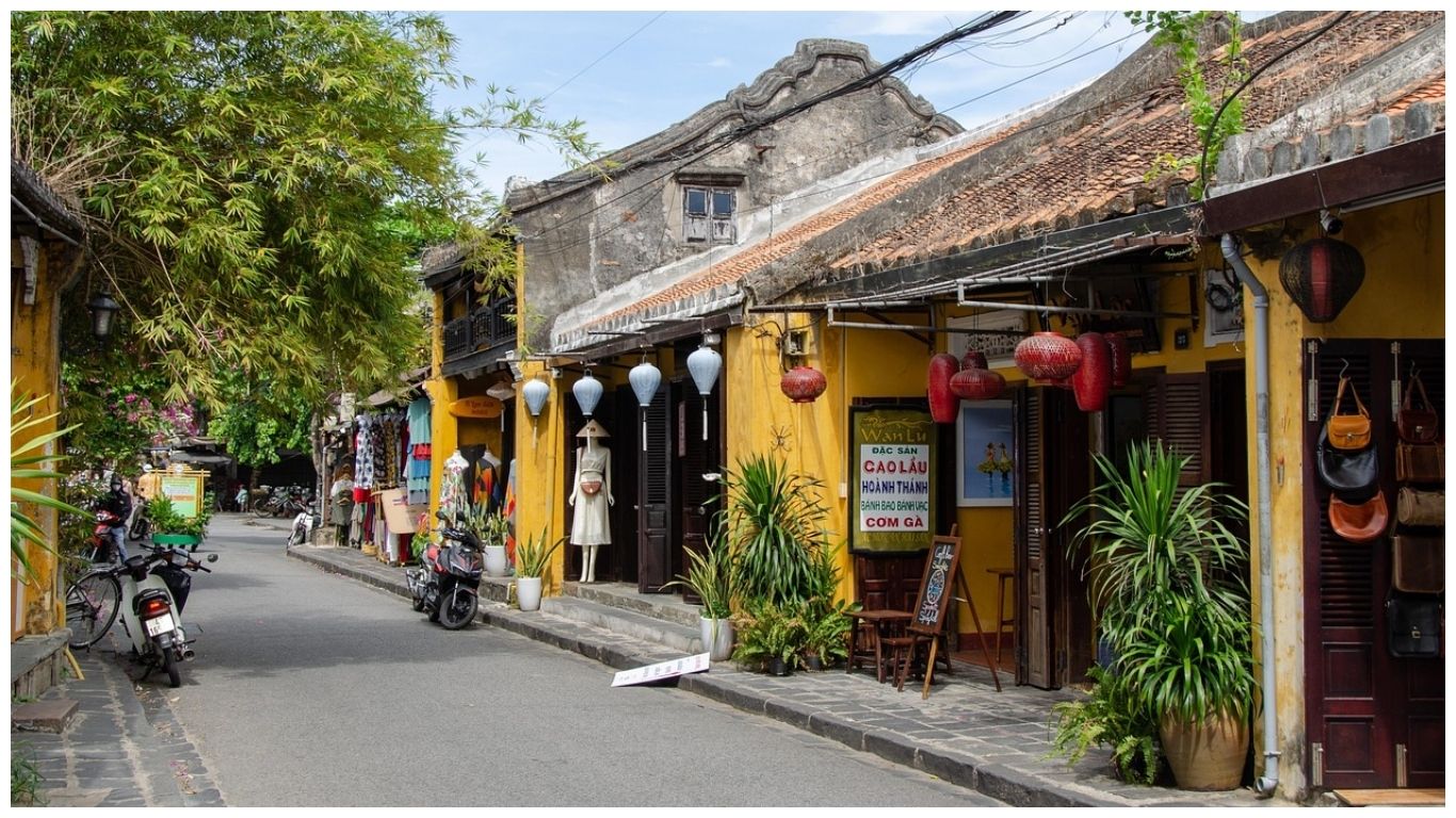 A charming street in Hoi An Ancient Town with yellow heritage buildings, silk lanterns, and local shops, showcasing the best things to do in Hoi An