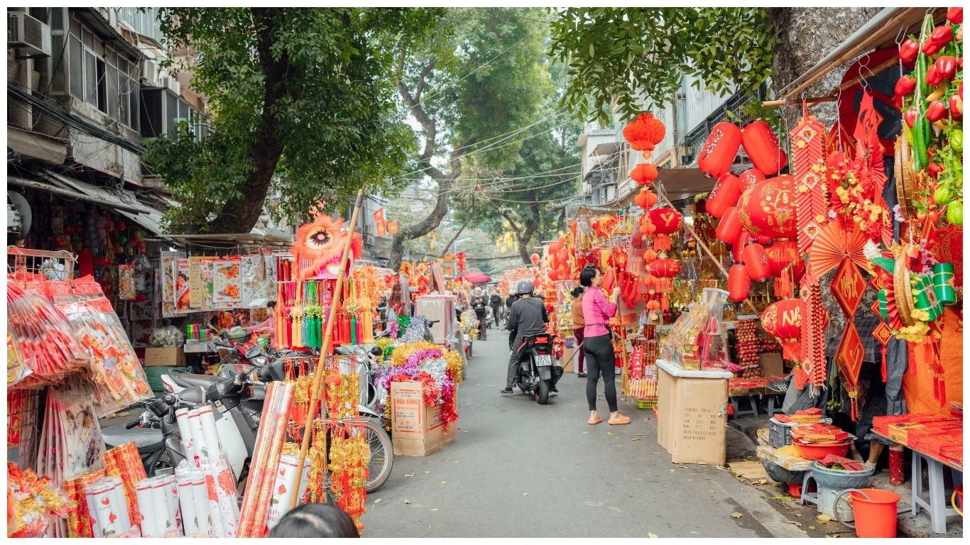 A colorful street in Hanoi's Old Quarter decorated with red lanterns and festive ornaments, highlighting the city's charm as a hub for day trips from Hanoi Vietnam