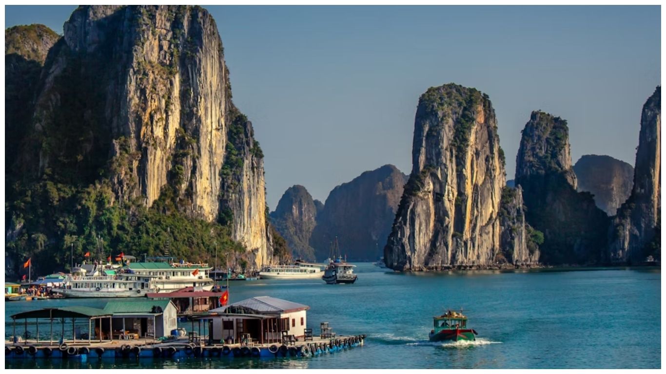 Floating houses and cruise boats surrounded by towering limestone karsts in Halong Bay, a top choice for day trips from Hanoi Vietnam