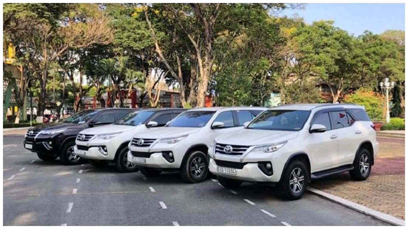 A fleet of modern white and black Toyota SUVs parked in a row, representing private car rental options for a flexible journey from Hanoi to Sapa
