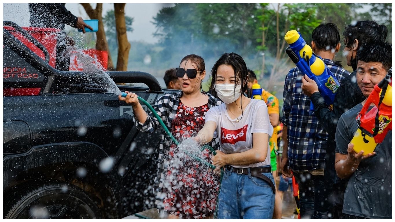 People celebrating Songkran with water guns and hoses, capturing one of the most vibrant fun facts about Thailand