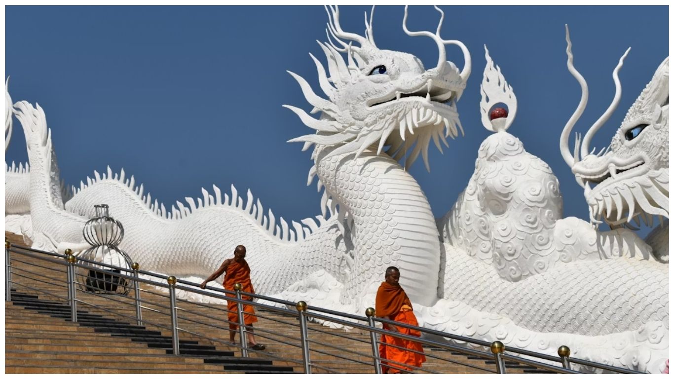 The famous White Temple (Wat Rong Khun) in Chiang Rai, one of the best places to visit in Thailand, showcasing its intricate white plasterwork and reflective glass design