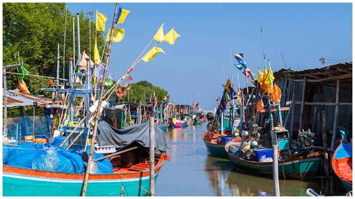 Colorful traditional fishing boats moored in a peaceful Thai village, inspiring travelers to explore more fun facts about Thailand