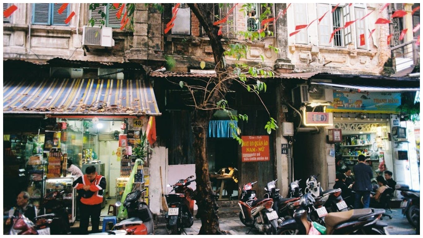 Busy street scene in Hanoi's Old Quarter with motorbikes and local shops, the starting point for many memorable day trips from Hanoi, Vietnam